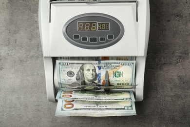 Modern bill counter with money on table, top view