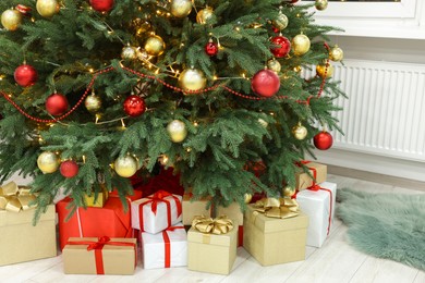Photo of Beautiful Christmas tree and many gifts indoors