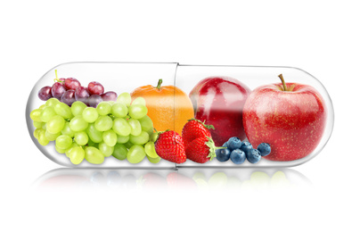 Image of Transparent capsule with different fruits and berries rich in vitamins on white background