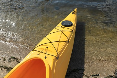 Yellow kayak on beach near river, closeup. Summer camp activity