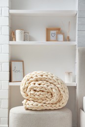 Photo of Soft chunky knit blanket on ottoman indoors
