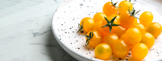 Ripe yellow tomatoes on white marble table, closeup