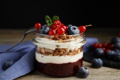 Delicious yogurt parfait with fresh berries and mint on wooden table, closeup