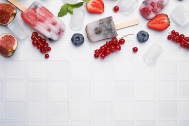Photo of Flat lay composition with berry ice pops on white table. Space for text