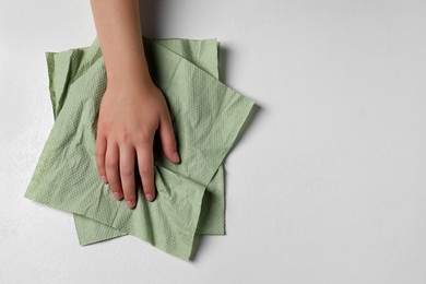 Woman cleaning light table with paper towel, top view. Space for text
