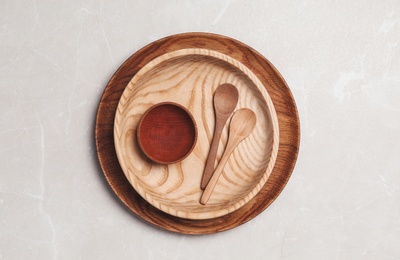 Wooden spoons and dishes on grey table, top view. Cooking utensils