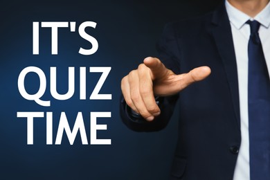 Man pointing at phrase IT'S QUIZ TIME on dark blue background, closeup view