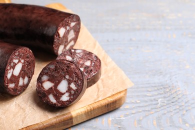 Tasty blood sausage on grey wooden table, closeup. Space for text