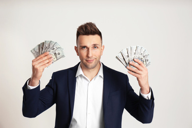 Photo of Confident man with cash money on light grey background