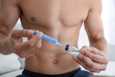 Man filling syringe with drug, closeup. Doping concept