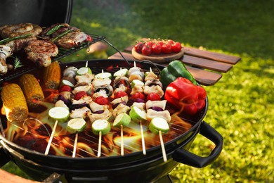 Cooking meat and vegetables on barbecue grill outdoors