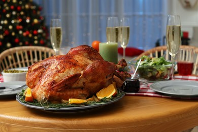 Festive dinner with delicious baked turkey and sparkling wine on table indoors. Christmas celebration