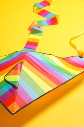 Beautiful bright rainbow kite on yellow background
