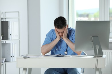 Photo of Exhausted doctor working at table in hospital