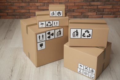 Cardboard boxes with different packaging symbols on floor. Parcel delivery