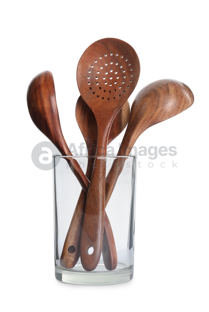 Set of wooden kitchen utensils in glass holder isolated on white