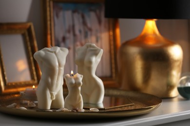 Beautiful body shaped candles on table indoors