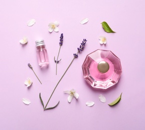 Photo of Flat lay composition with elegant perfume on lilac background
