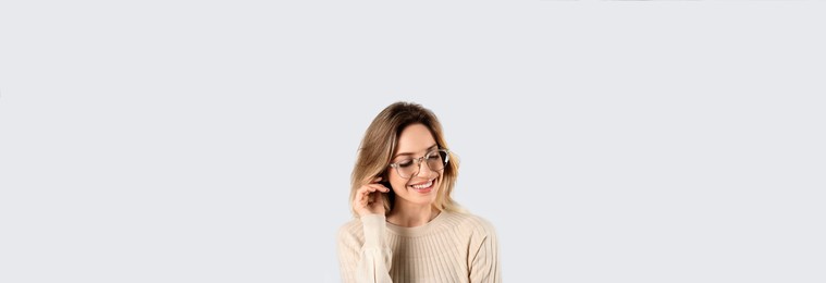 Image of Portrait of happy young woman with beautiful blonde hair and charming smile on light background. Horizontal banner design
