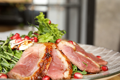 Photo of Delicious salad with roasted duck breast on plate, closeup