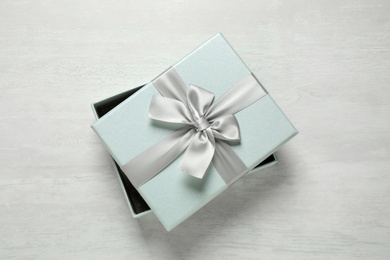 Beautiful gift box with bow on white table, top view