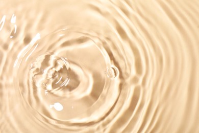 Closeup view of water with rippled surface on beige background