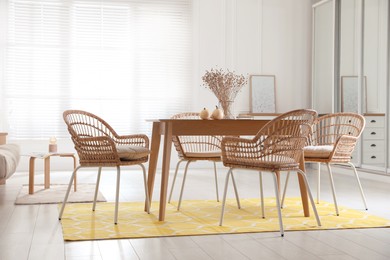 Dining room interior with wooden table and wicker chairs