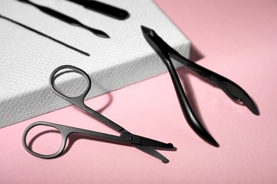 Photo of Set of manicure tools on pink background, closeup view