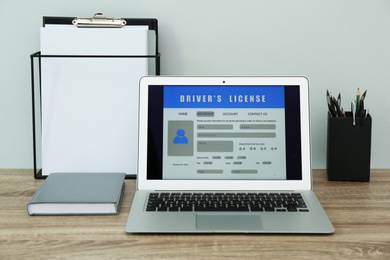 Laptop with driver's license application form on table in office