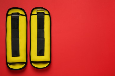 Yellow weighting agents on red background, flat lay. Space for text