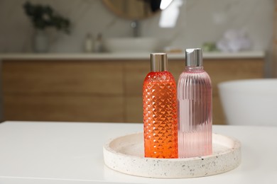 Bottles of shower gels on white table in bathroom, space for text