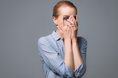 Photo of Young woman feeling fear on grey background