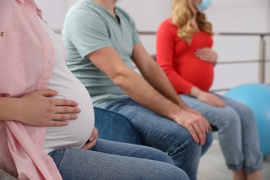 Pregnant women and man at courses of expectant parents, closeup