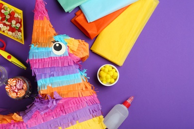 Photo of Flat lay composition with cardboard donkey on purple background, space for text. Pinata diy