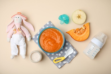 Flat lay composition with bowl of healthy baby food on color background