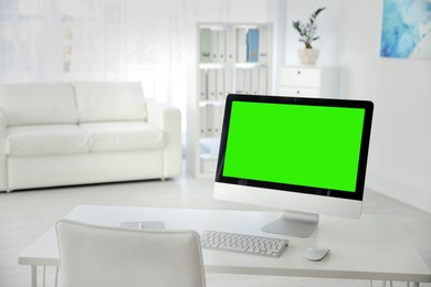 Image of Computer display with chroma key on desk indoors. Comfortable workplace