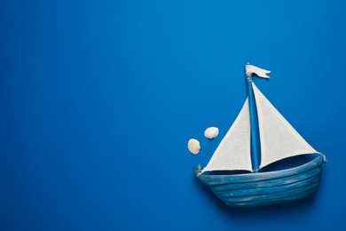 Photo of Toy ship on bright background, top view with space for text. Color of the year 2020 (Classic blue)