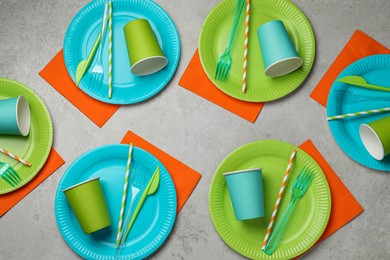 Flat lay composition with disposable tableware on light background