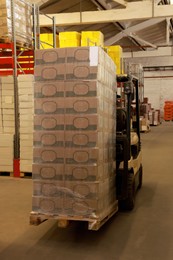 Forklift truck with boxes in warehouse. Logistics concept