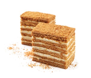 Photo of Slices of delicious layered honey cake on white background