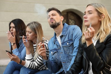 Photo of People smoking cigarettes at public place outdoors