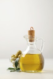 Bottle of fresh olive oil on white table
