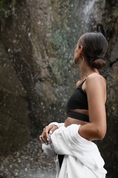 Photo of Young woman in stylish bikini near waterfall outdoors
