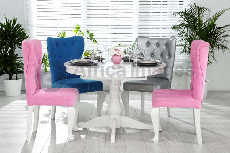 Photo of Elegant dining room interior with stylish chairs and table