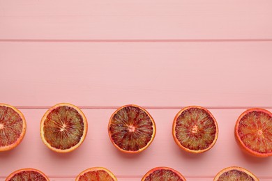 Many ripe sicilian oranges on pink wooden table, flat lay. Space for text