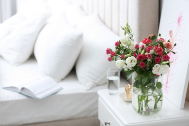 Glass vase with fresh flowers in bedroom