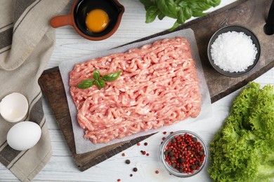 Raw chicken minced meat and ingredients on white wooden table, flat lay