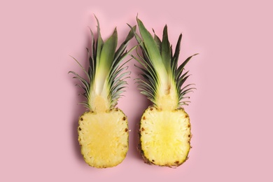 Photo of Halves of pineapple on pink background, flat lay