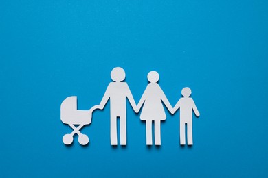 Paper family figures on light blue background, top view. Insurance concept