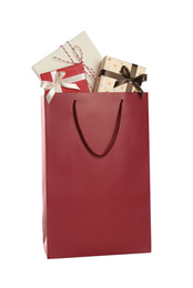 Paper shopping bag full of gift boxes isolated on white